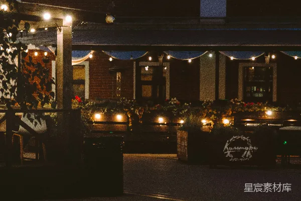 高清摄影 夜晚户外餐厅的座位区，装饰着串灯。