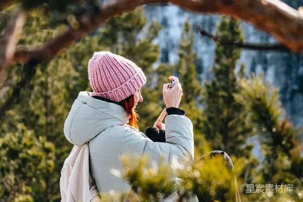 高清摄影 一个女人坐在岩石上拍照。
