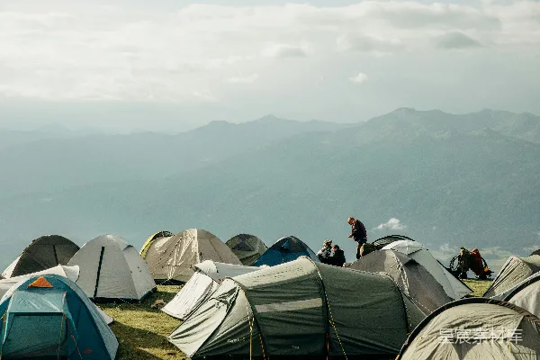 高清摄影 许多帐篷坐落在草地上，远处是山脉。
