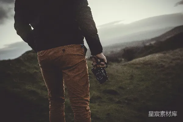 高清摄影 站在山顶的男人手持黑色数码相机