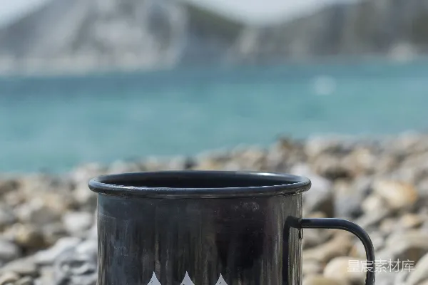 高清摄影 白天岩石岸边的黑白陶瓷杯