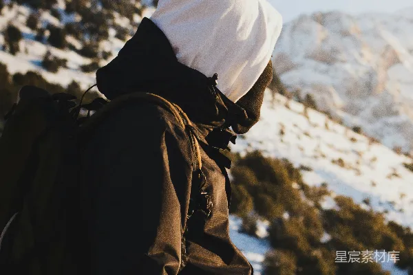 高清摄影 穿着冬装的徒步旅行者欣赏着雪景中的山地景色。