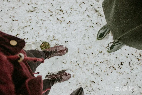高清摄影 两个人站在雪地里，低头看。