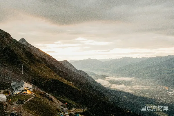 高清摄影 晨曦中的山景，远处可见山谷和露营地。