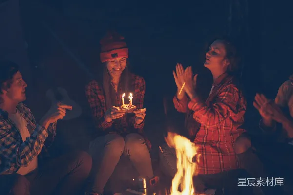高清摄影 朋友们在夜晚围着篝火庆祝生日。
