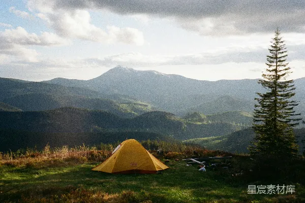 高清摄影 一顶黄色的帐篷搭在山景中。