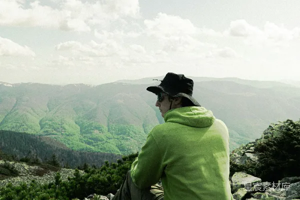 高清摄影 戴着帽子的徒步旅行者在岩石山顶欣赏着山景。