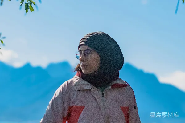 高清摄影 穿着夹克和针织帽的女人正眺望着山脉。