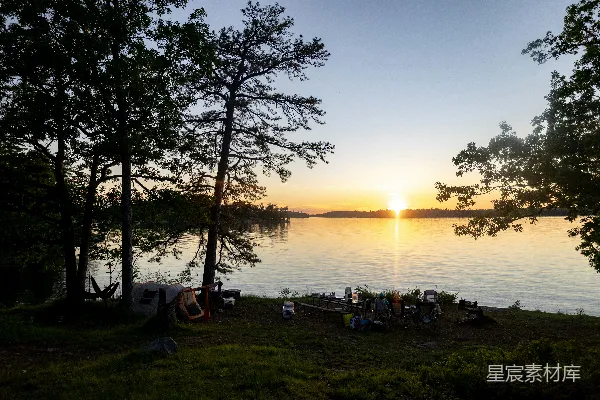 高清摄影 在夕阳下，朋友们在湖边露营。