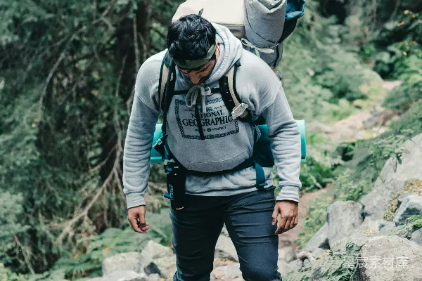 高清摄影 穿着黑色和灰色夹克，戴着黑色头盔的男人站在岩石山地上方，白天。
