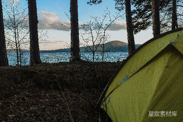 高清摄影 湖边的帐篷周围是松树。
