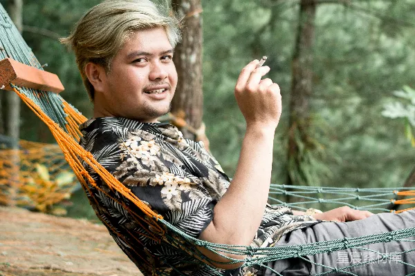 高清摄影 一个男人坐在树林里的吊床上