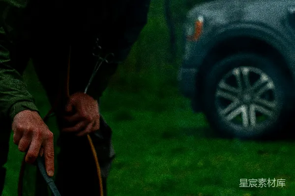 高清摄影 一个人正在雨中户外烹饪土豆。