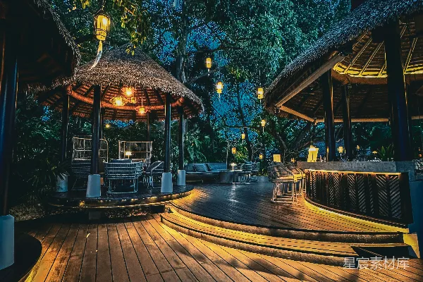 高清摄影 夜晚的热带度假村，灯火辉煌的凉亭和木质露台。