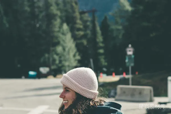 高清摄影 穿着黑色夹克和白色针织帽的女人站在白天的道路上。