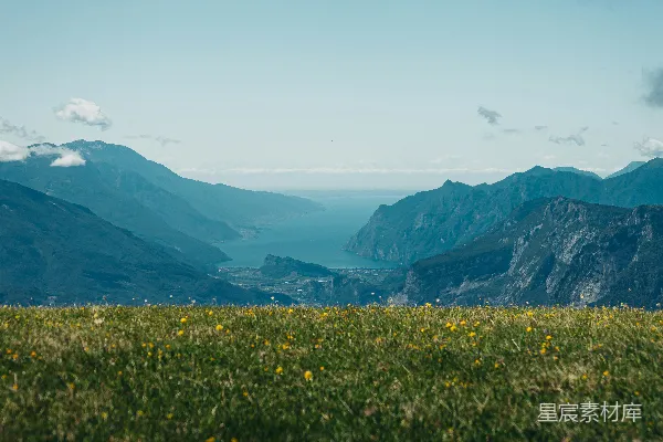高清摄影 绿草如茵的山丘俯瞰着宁静的湖泊，周围环绕着群山。