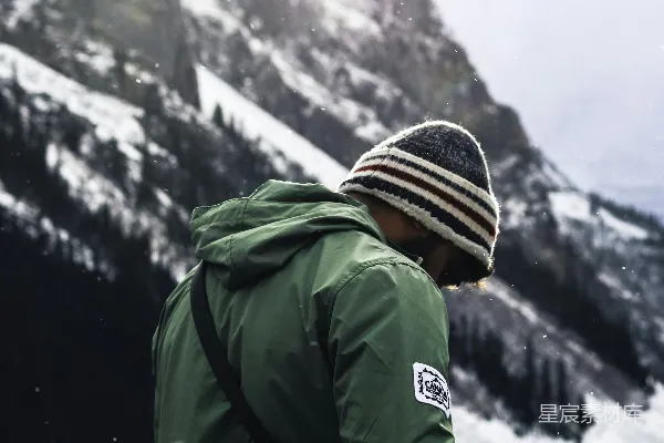 高清摄影 一个穿着绿色夹克的男人站在雪地里