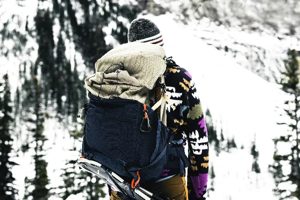 高清摄影 背着背包、拿着滑雪板站在雪地里的人