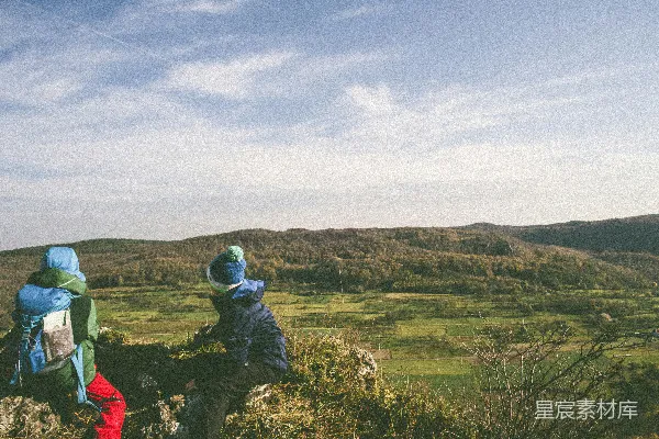 高清摄影 两个人坐在岩石上，靠近山。