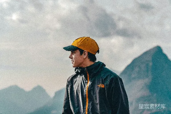 高清摄影 穿着蓝色夹克和黄色帽子的男人站在白天的山上。