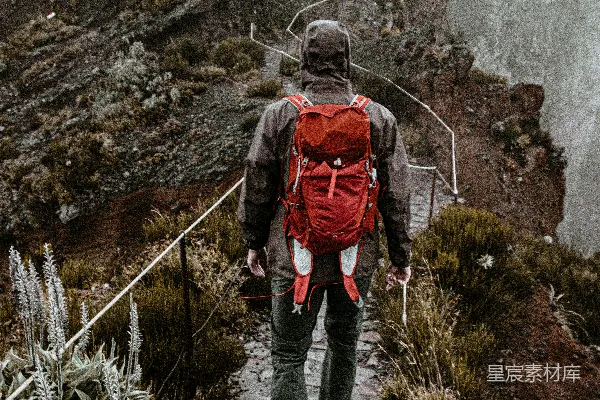 高清摄影 一个背着红色背包的男人正在爬山