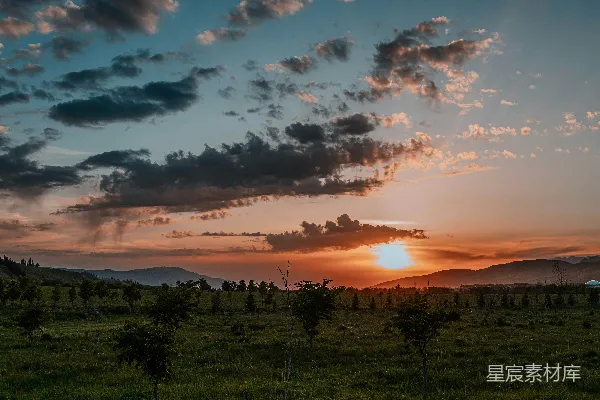 高清摄影 绚丽的夕阳天空映衬着广阔的绿色景观。
