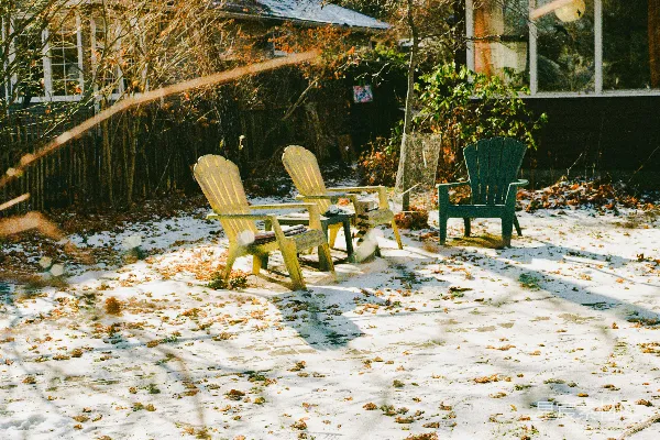 高清摄影 三把椅子放在一个覆盖着雪的后院里。