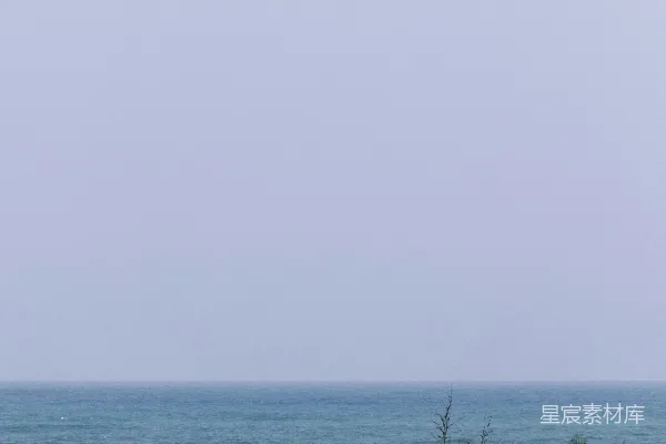 高清摄影 两顶白色的星星帐篷矗立在绿色草坪上，背景是海洋。