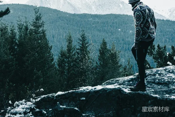 高清摄影 一个男人站在覆盖着雪的山顶上。