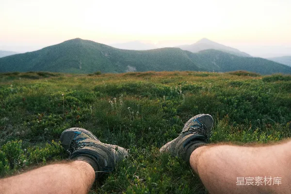 高清摄影 坐在草地上的一座山丘上，俯瞰着远处的小山。