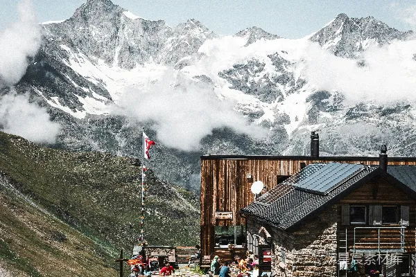 高清摄影 一群人坐在山顶小屋外面。