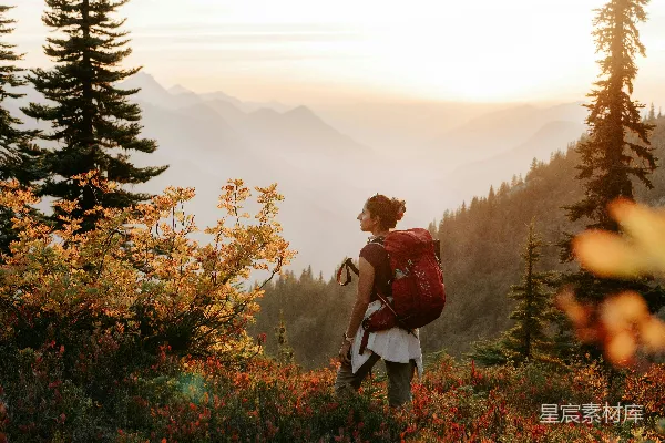 高清摄影 背着背包的女人在日落时分在山上徒步旅行