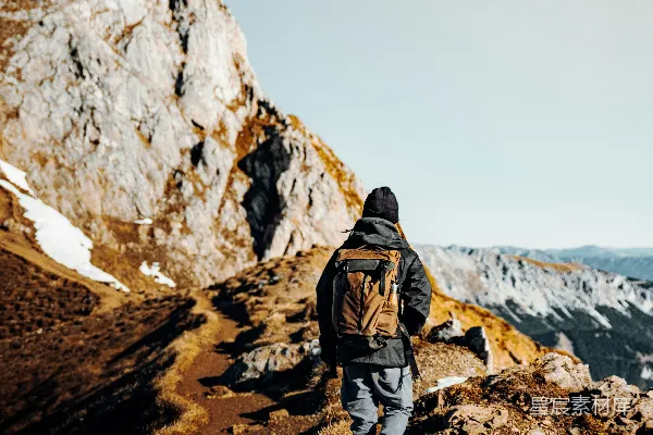 高清摄影 穿着棕色夹克和灰色裤子的男人站在白天的棕色岩石山上。