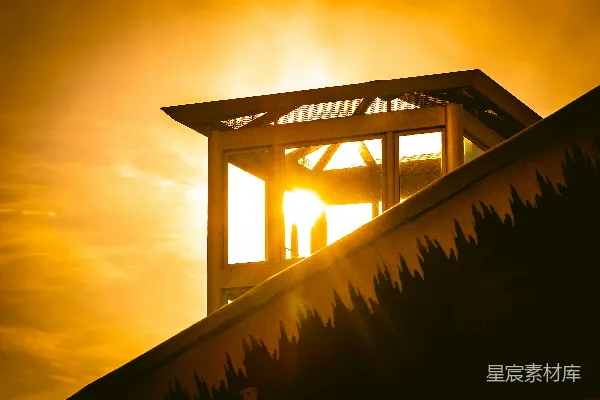 高清摄影 夕阳落在这座带屋顶的建筑物后面。