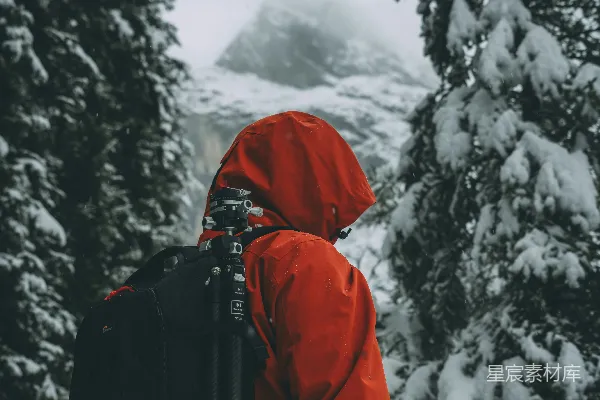 高清摄影 穿红色夹克背着背包的人在雪林中
