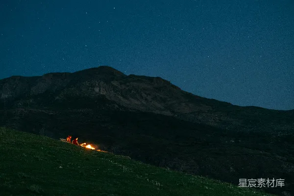 高清摄影 在星空下，草地上有一堆篝火。