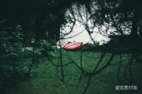 高清摄影 白天，绿色草地旁的树林附近，有一个红白相间的帐篷。