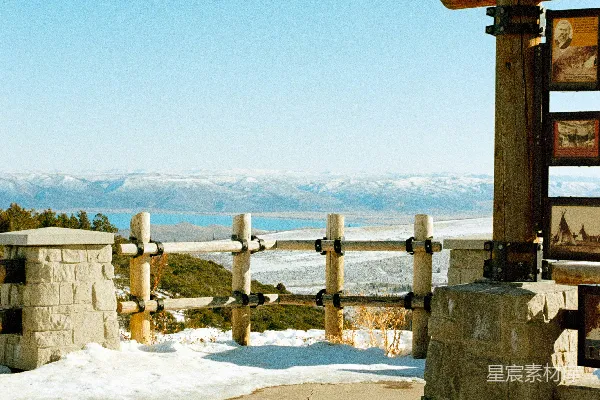 高清摄影 木制凉亭俯瞰着白雪覆盖的景观，远处的山脉隐约可见。