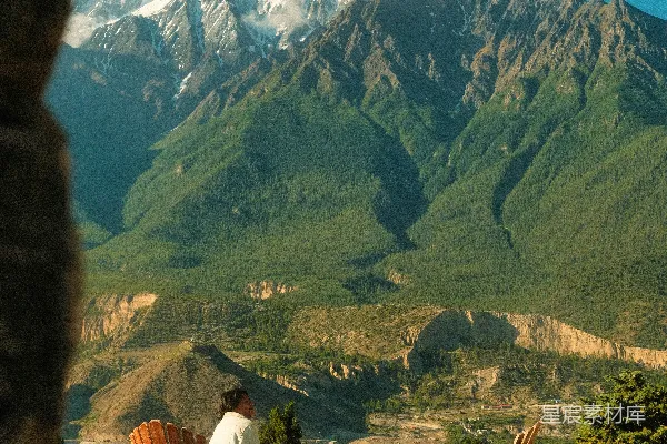 高清摄影 这个人坐在露台椅上欣赏着山景。