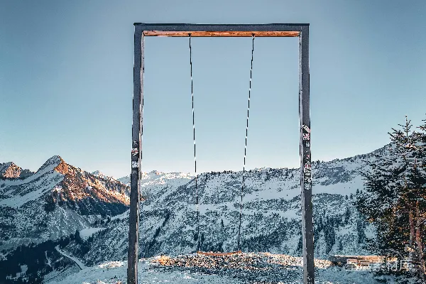 高清摄影 一个秋千架俯瞰着积雪覆盖的山脉景观。