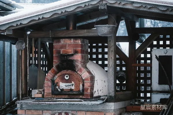 高清摄影 一座砖炉子坐落在积雪覆盖的院子里。