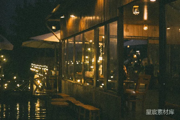 高清摄影 温馨的咖啡馆外景，夜晚温暖的串灯装饰。
