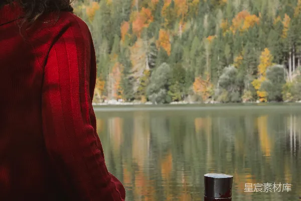 高清摄影 一个女人坐在湖边的地上。