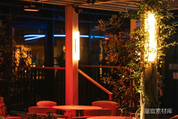 高清摄影 夜晚，温暖的灯光照亮了户外座位区。