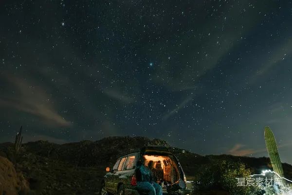 高清摄影 在星空下，夫妻俩从车里看星星。