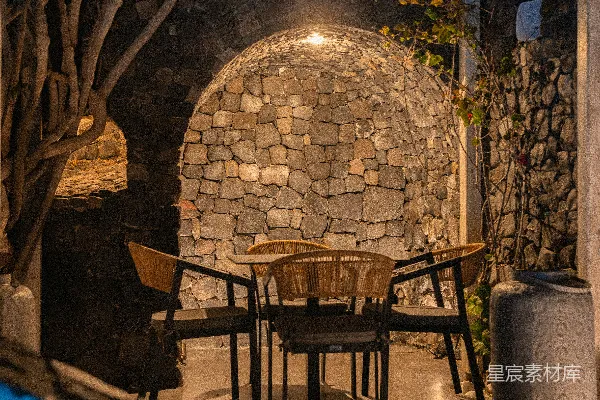 高清摄影 温馨的户外用餐区，夜晚时有石墙环绕。