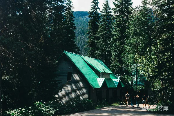 高清摄影 一个绿顶小屋隐藏在高大的树木和群山之间。