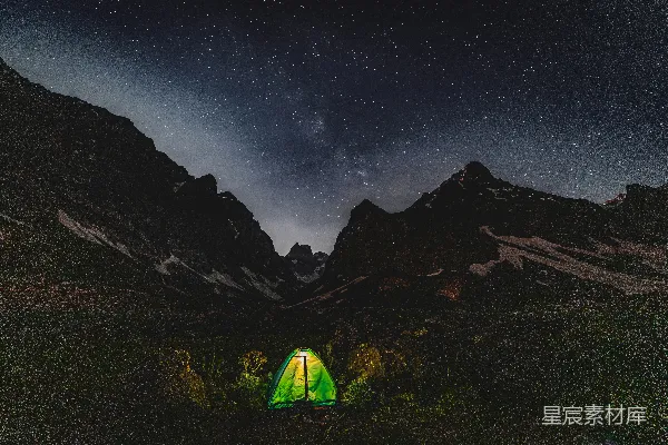 高清摄影 在星空下的黑暗山谷里，帐篷被灯光照亮。