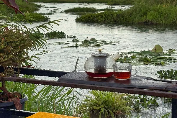 高清摄影 一套茶具放在一张桌子旁，桌子旁边是宁静的河流风景。