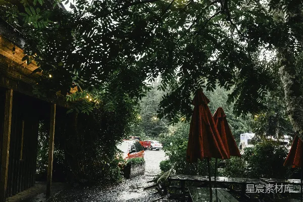 高清摄影 雨天里，红色雨伞下的野餐桌